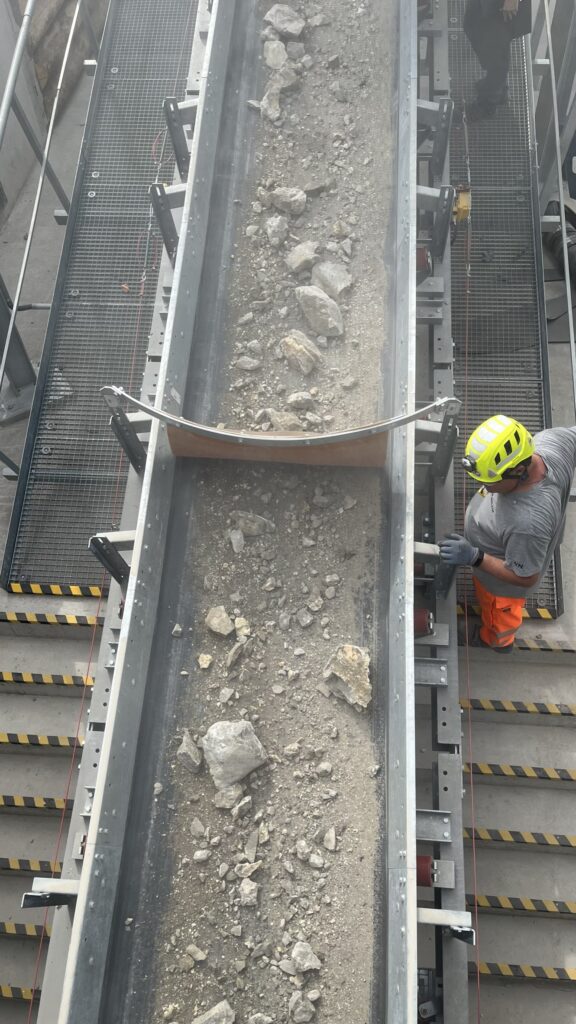 Pre-crushed concrete on conveyor belt during secondary crushing
